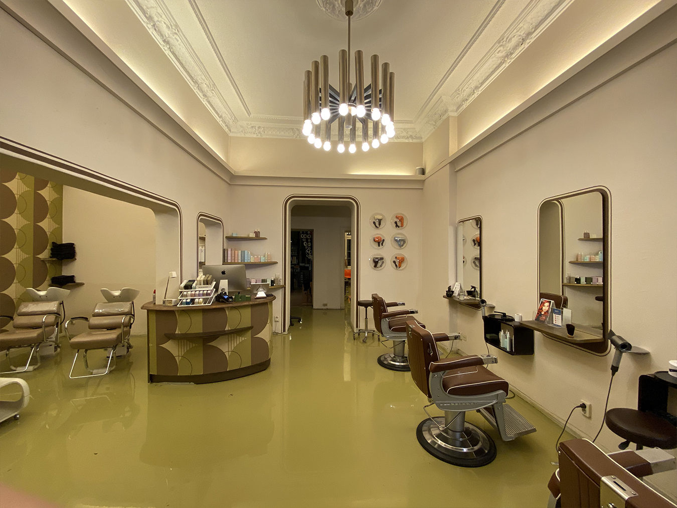 Innenraum des Salons Haareszeiten mit Stylist:innen bei der Arbeit